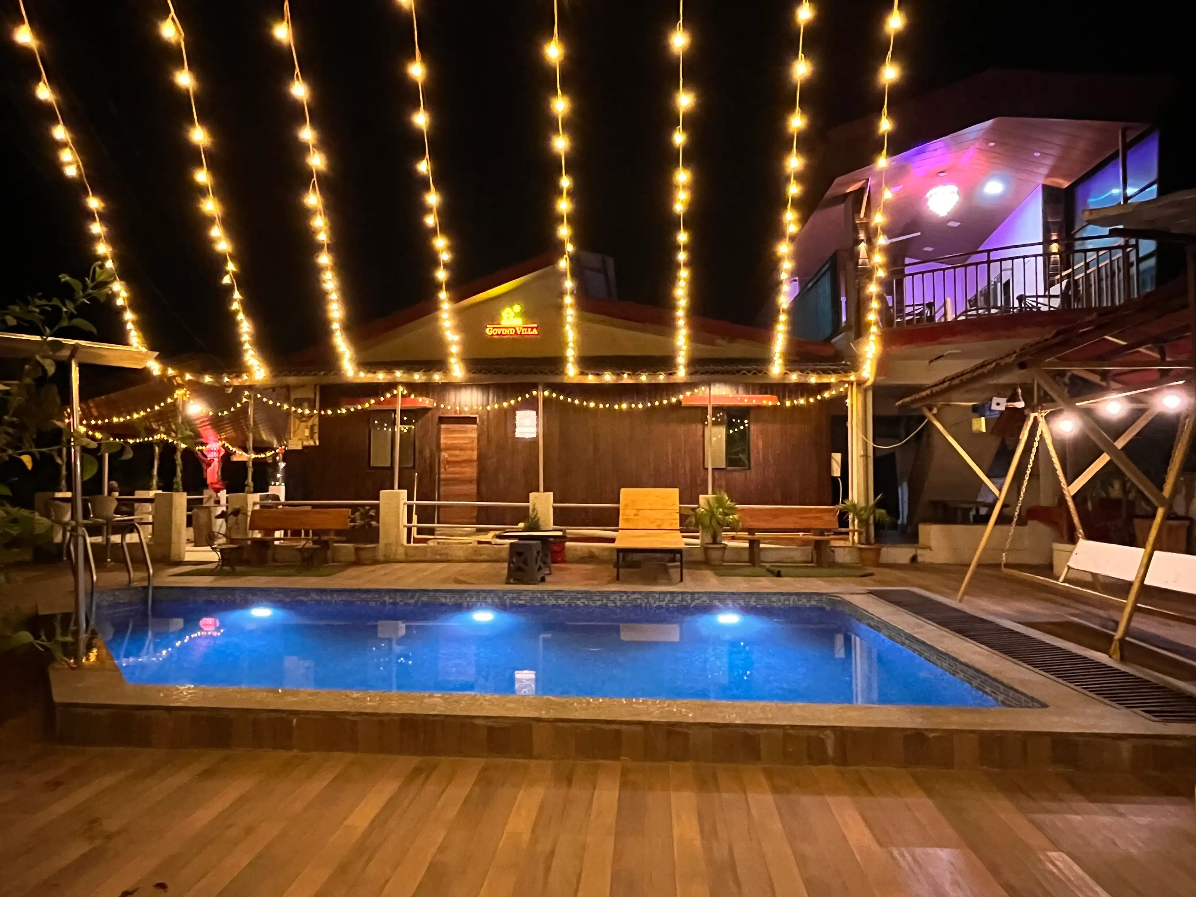 A mesmerizing close-up of Govind Villa’s private pool, reflecting the golden glow of warm lighting, creating a tranquil and inviting atmosphere.